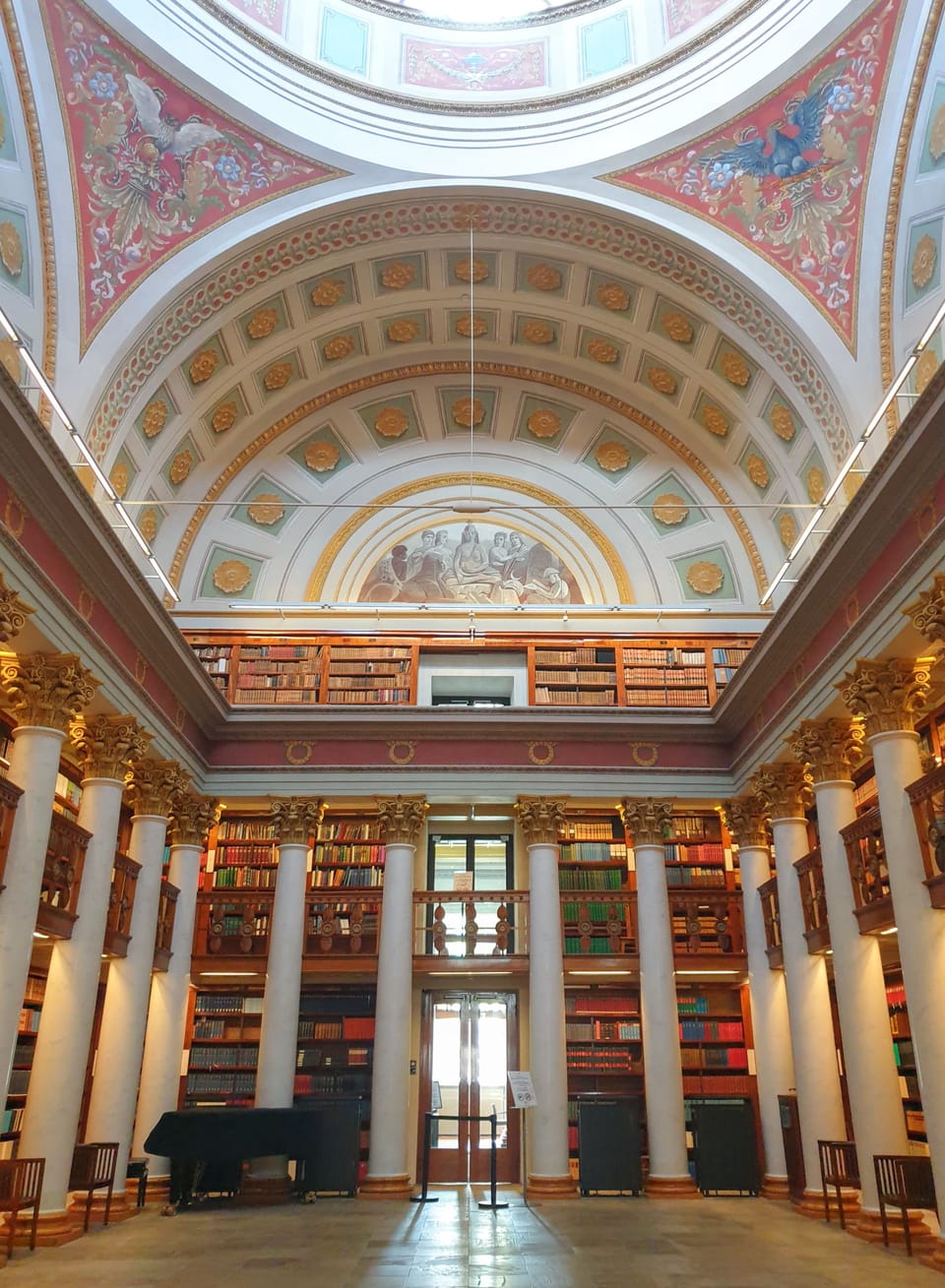 The Cupola Hall with its high painted ceiling, white columns, and numerous bookshelves.